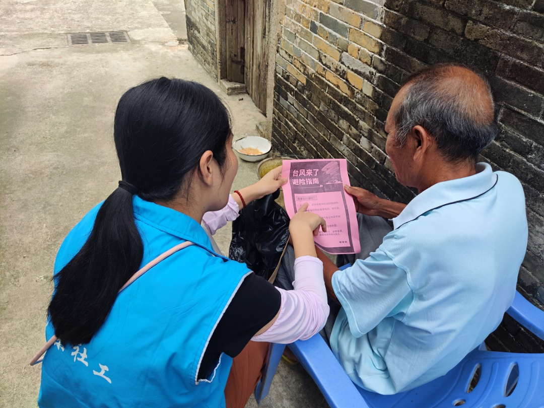 “雙百”社工為老人制作防風(fēng)避險(xiǎn)指南，并解說防御臺(tái)風(fēng)知識(shí).png